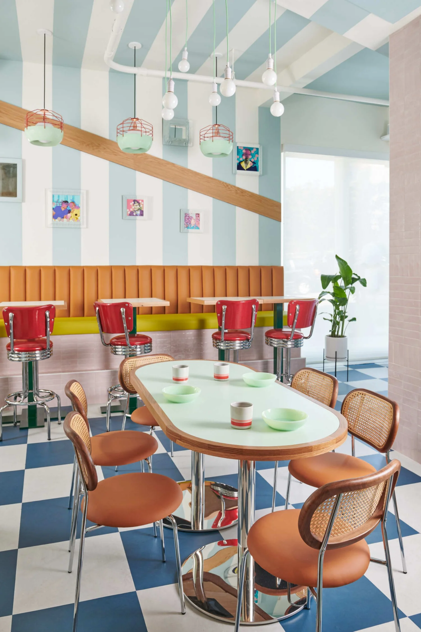 Interior of Hilda and Jesse. Striped wallpaper, diner chairs, and blue checkered floor.