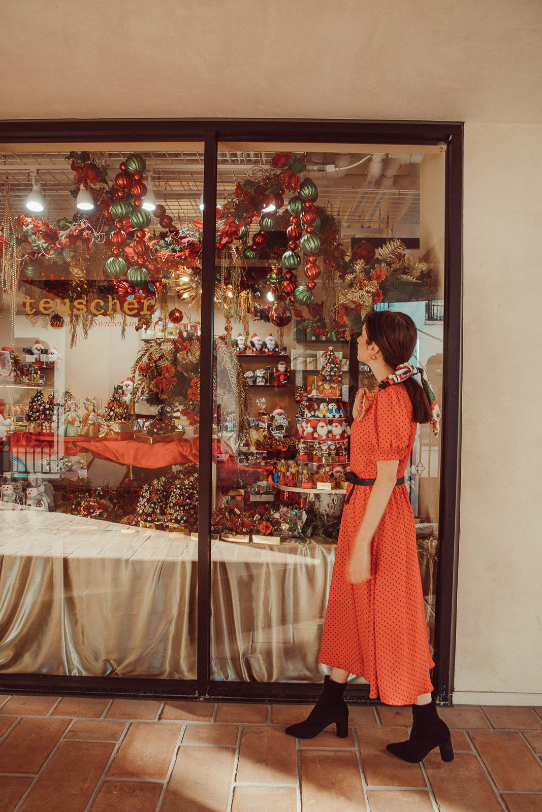 Woman wearing festive red polka dot dress and black heeled boots - 5 Creative Christmas Photoshoot Ideas to Try This Season