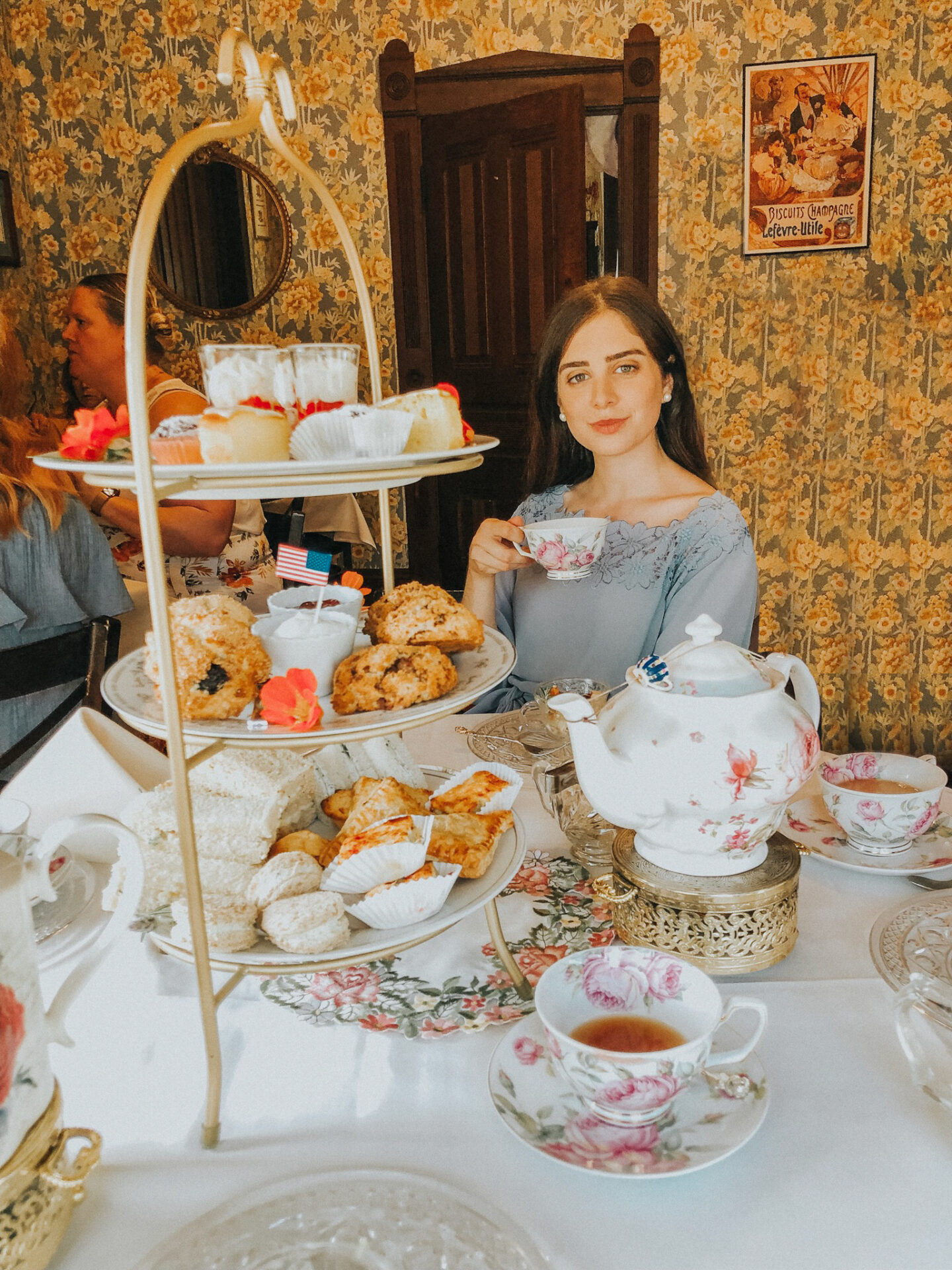 Things to do in Old Town San Diego Afternoon Tea at Coral Tree, woman sitting drinking tea with tower of teacakes in front of her