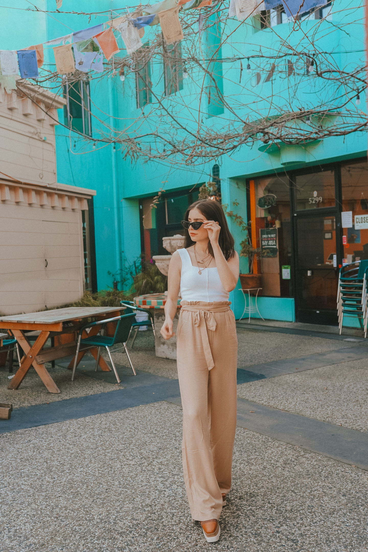 Tan high waisted paper bag pants and white tank top with gold jewelry - Palm Trees and Pellegrino