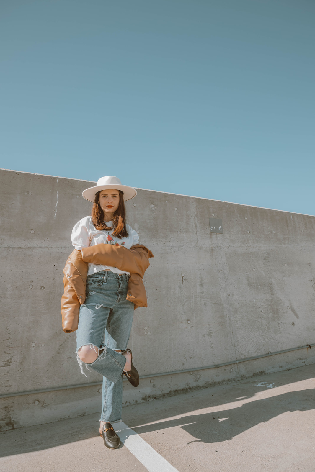 Effortlessly chic outfit, graphic tee, distressed jeans, wide brim hat, and leather puffer jacket Pinterest outfit  - Palm Trees and Pellegrino