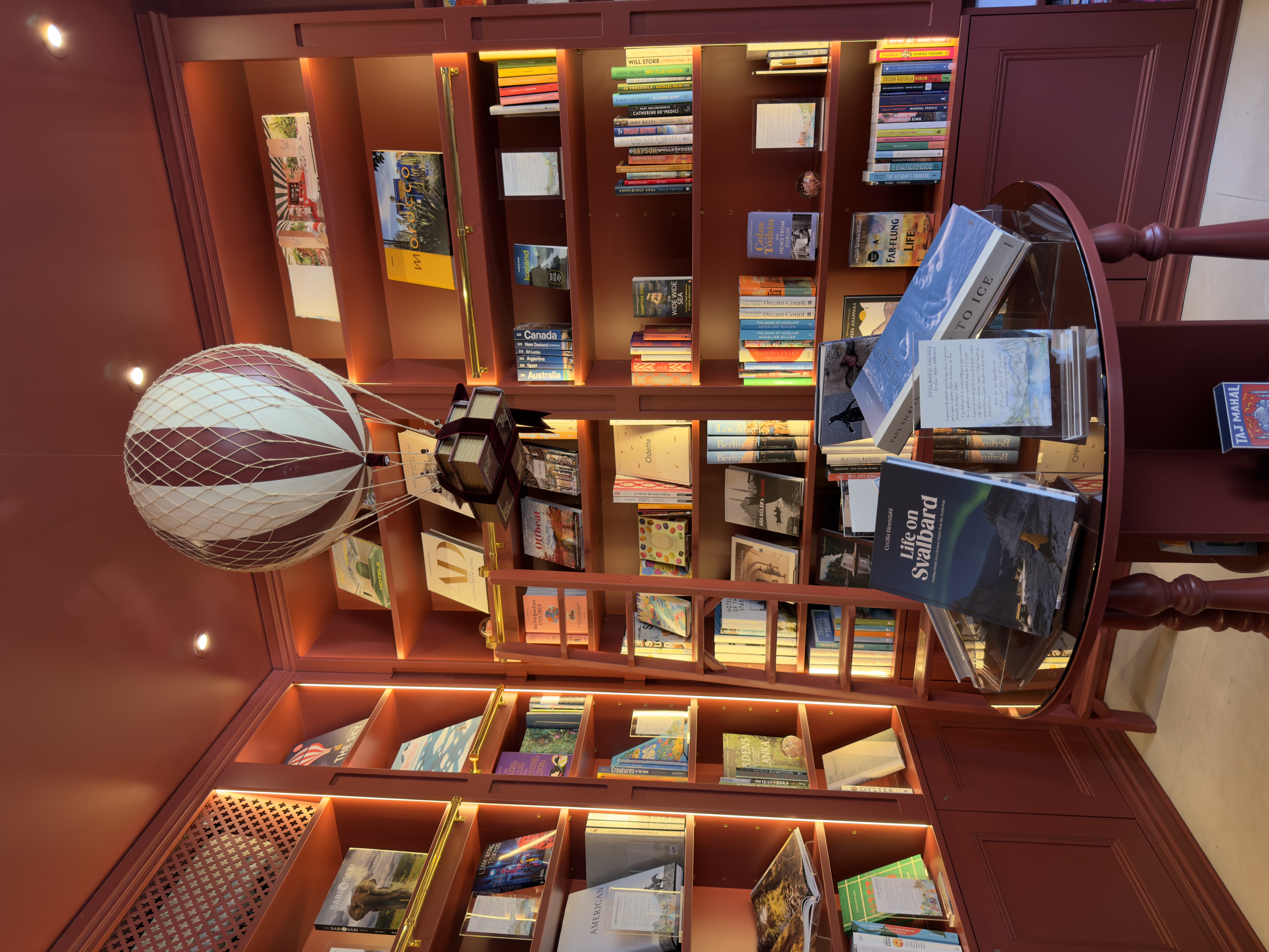 Inside Travellers' Tales, Marylebone's intimate travel bookshop, with floor-to-ceiling shelves and a hot air balloon hanging from the ceiling.